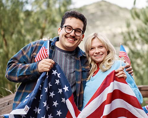 Happy Couple with USA Flag Celebrating Home Purchase in Texas